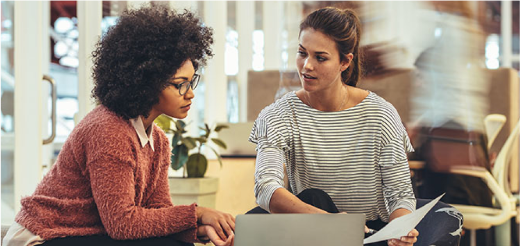 two women looking at a laptop