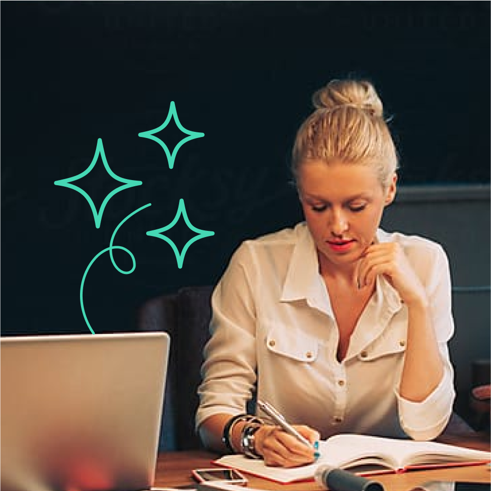 a woman sitting at a desk writing in a notebook